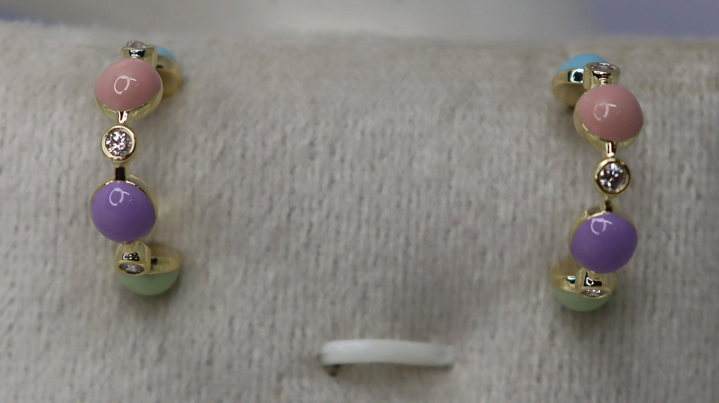 Pair of beaded earrings on a gray display stand with a blurred background