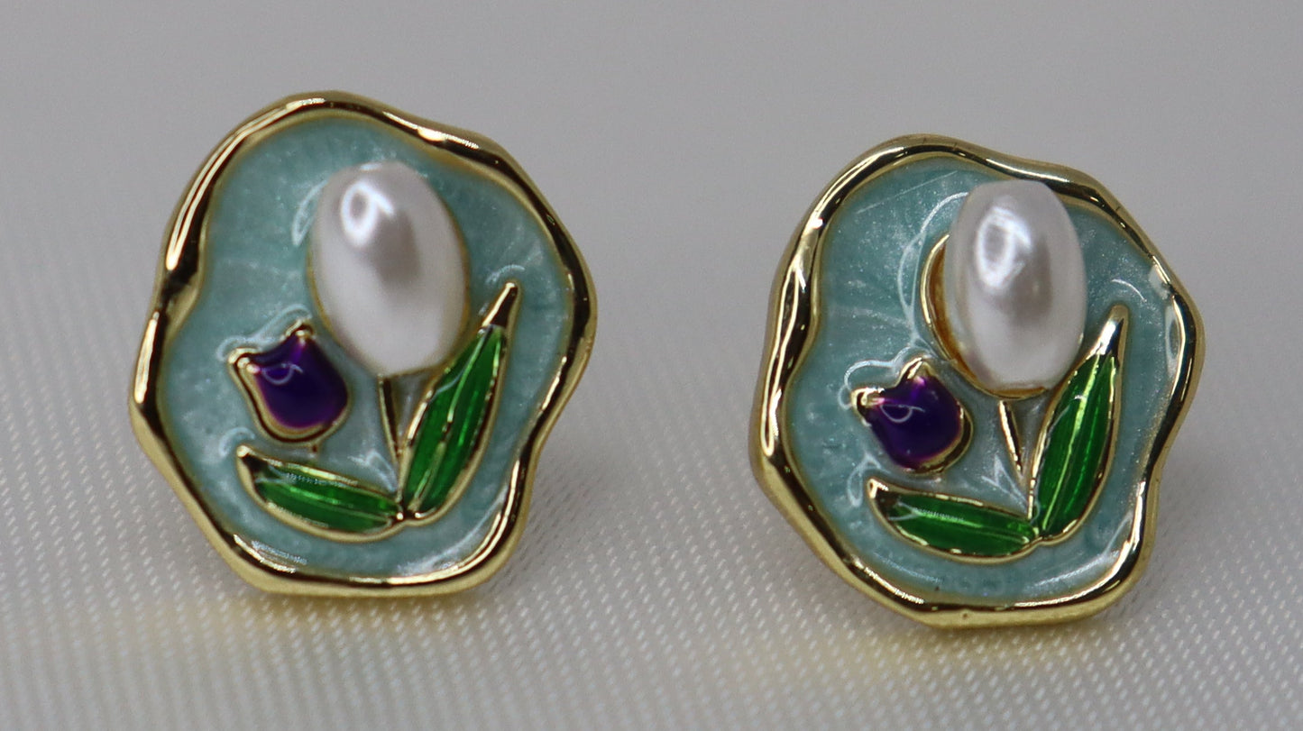 Pair of earrings with pearl-like stones on a light gray background