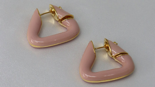 Pink triangle-shaped earrings with gold accents on a light gray background